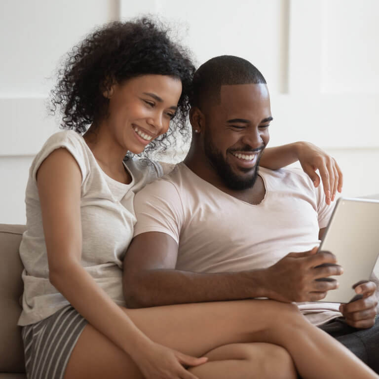 couple smiling and reading reviews on a tablet