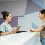 Patient checking in at Woodcreek Dental Care reception desk in Calgary SW