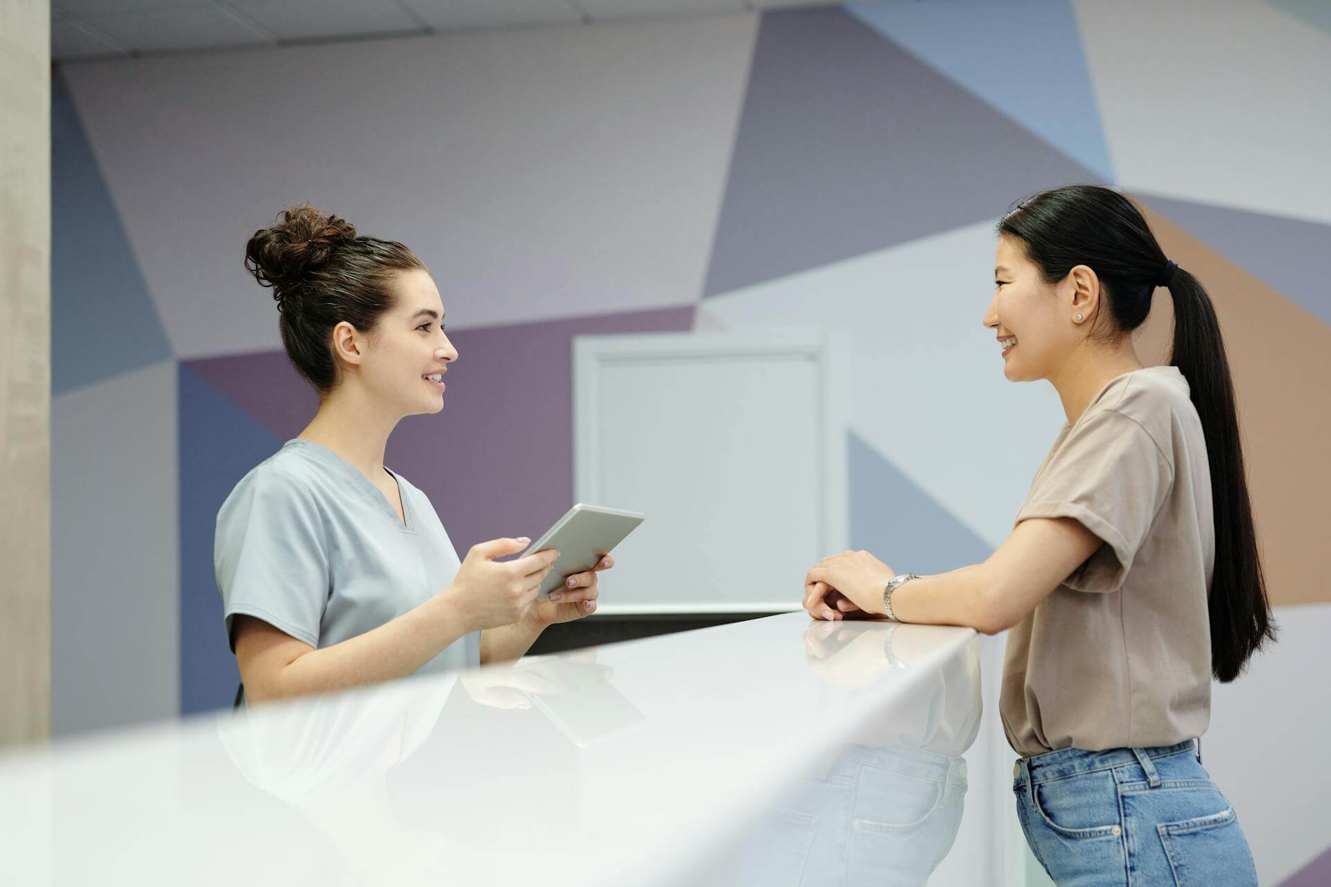 Patient checking in at Woodcreek Dental Care reception desk in Calgary SW